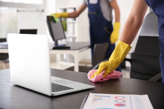 Espace de travail de bureau avec produits de nettoyage professionnel disposés sur un plan de travail blanc